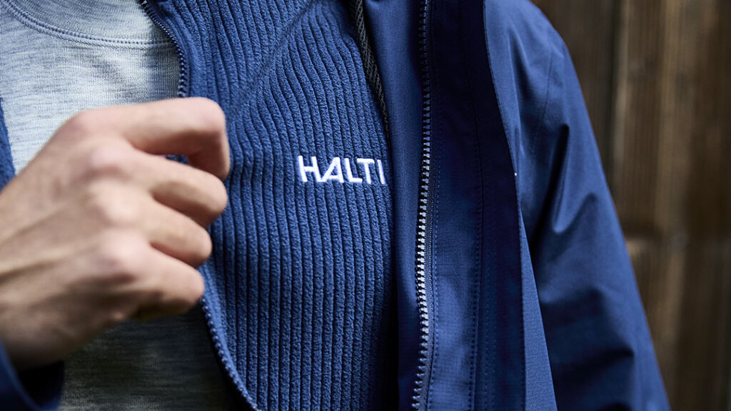 Miehellä siniset Haltin fleece- ja kuoritakit