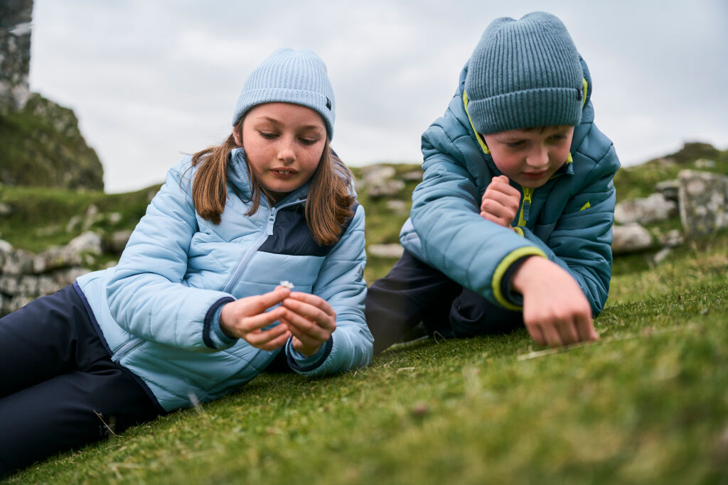 Kaksi lasta makaa nurmikolla